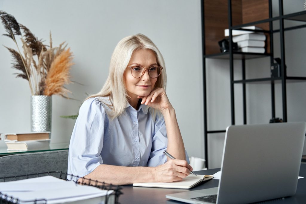 Middle aged woman watching professional training class online virtual meeting.